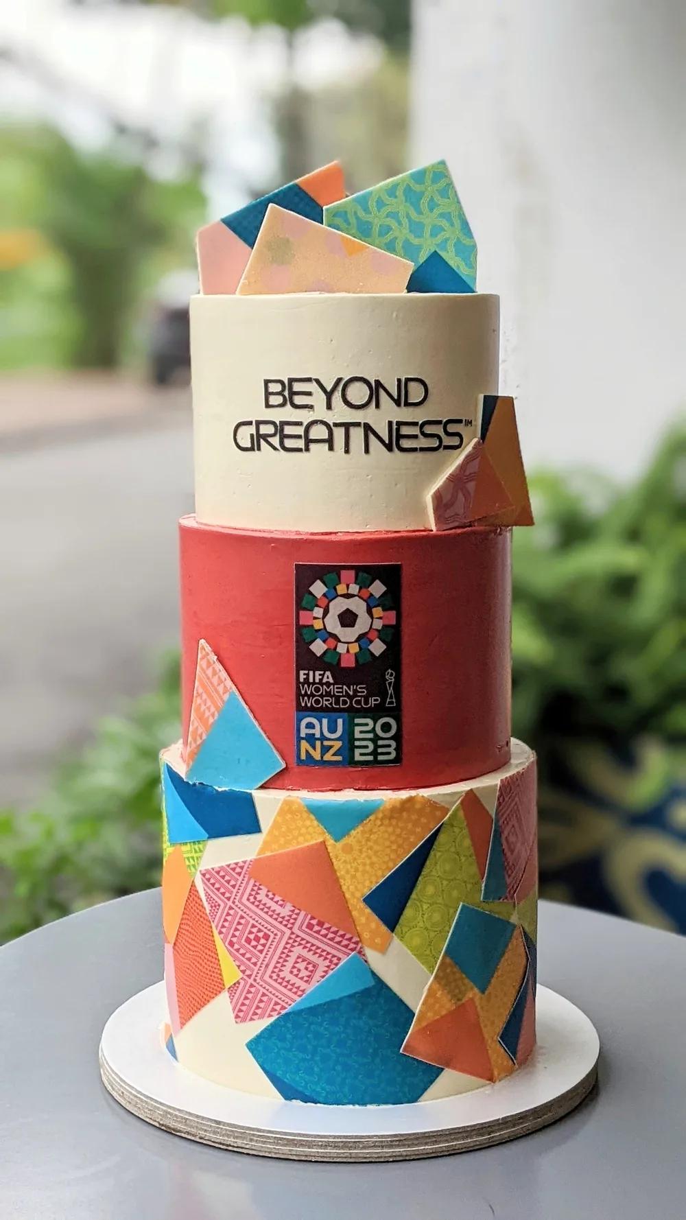 three-tier cake wrapped in colourful geometric edible prints with patterned chocolate shards